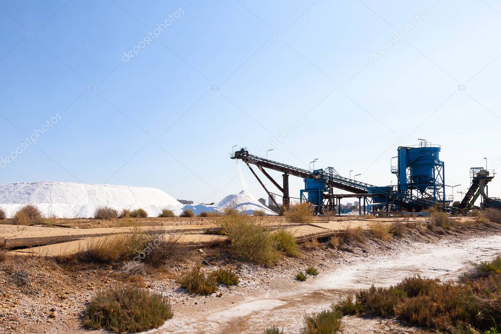 Salt production, conveyor belt with marine salt produced by the evaporation of seawater.