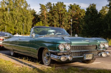 Tallinn, Estonya - 16 Temmuz 2025: Güneşli bir yaz akşamı şehir caddesinde park edilmiş klasik açık yeşil Cadillac 62 1959 model Cabriolet. Eski araba stoku ve nostalji..