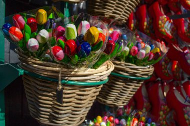 Bir dükkanda sergilenen ve Hollanda temalı seyahat, hediye, kutlama ya da çiçek dekoru kavramları için güneş ışığıyla aydınlatılan renkli ahşap lale demetleri..