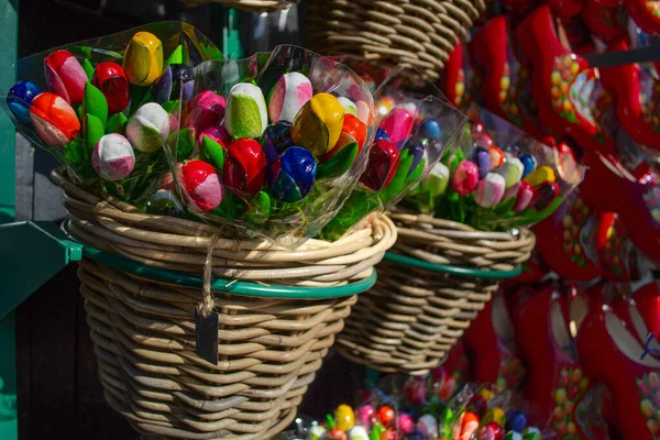 Bir dükkanda sergilenen ve Hollanda temalı seyahat, hediye, kutlama ya da çiçek dekoru kavramları için güneş ışığıyla aydınlatılan renkli ahşap lale demetleri..