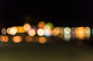 Akşam alacakaranlık deniz yüzey su arka plan üzerinde yansıtan ışık altın bokeh bulanık.