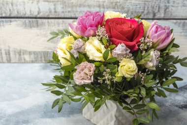 Muhteşem hafif bir arka plan üzerinde beyaz bir vazoda gül buketi 