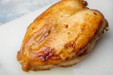 Bir kesme tahtası üzerinde kızarmış tavuk göğsü. Altın kabuk