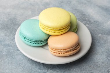 Lezzetli, renkli kurabiye macarons plaka üzerinde. Açık renkli 
