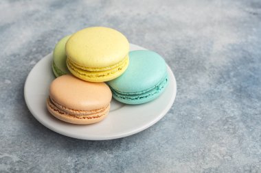 Lezzetli, renkli kurabiye macarons plaka üzerinde. Açık renkli 