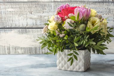 Muhteşem hafif bir arka plan üzerinde beyaz bir vazoda gül buketi 