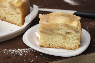 Elmalı turta bir plaka üzerinde bir parça. Ahşap arka plan üzerinde lezzetli Charlotte