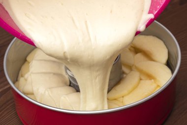 Elmalı turta (Charlotte), pişirme aşaması bir meyilli katmanla dökülen. Ahşap arka plan. Yakın çekim 