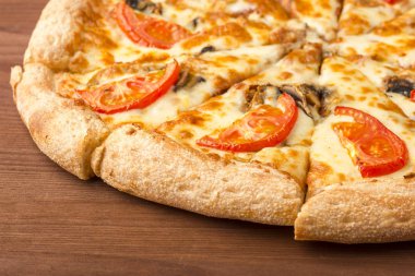 Peynirli pizza mantar ve ahşap arka plan üzerinde domates dilimleri. Yakın çekim