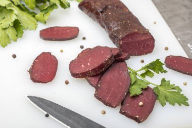 Yeşillikleri ile kesme tahtası üzerinde kurutulmuş et  