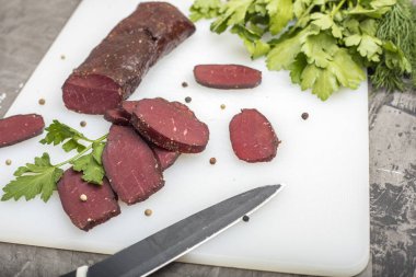 Yeşillikleri ile kesme tahtası üzerinde kurutulmuş et  