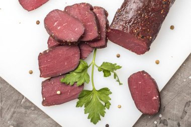 Yeşillikleri ile kesme tahtası üzerinde kurutulmuş et. Yukarıdan görüntülemek