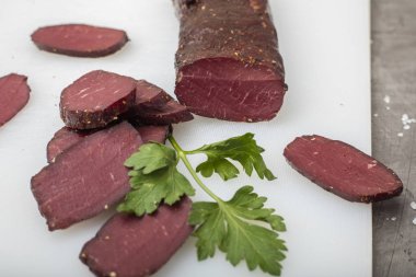 Yeşillikleri ile kesme tahtası üzerinde kurutulmuş et