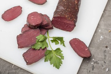 Yeşillikleri ile kesme tahtası üzerinde kurutulmuş et