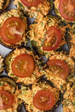 Sebzeler, havuç ve Yeşiller, fırında patlıcan domates dilimleri ile dekore edilmiştir. Üstten görünüm 