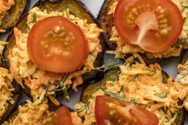 Sebzeler, havuç ve Yeşiller, fırında patlıcan domates dilimleri ile dekore edilmiştir. Üstten görünüm 