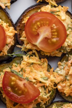 Sebzeler, havuç ve Yeşiller, fırında patlıcan domates dilimleri ile dekore edilmiştir. Üstten görünüm 