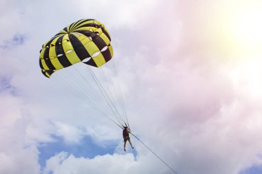paraşüt ile bir tekne tarafından ourists sinek. Sarı ve siyah paraşüt gökyüzünde uçan bir adam. Metniniz için kopya alanı