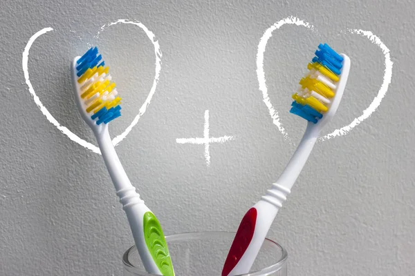 Hafif bir arka plan ve iki kalp artı işareti olan iki diş fırçaları. Aşk ve Sevgililer günü. Kopya alanı