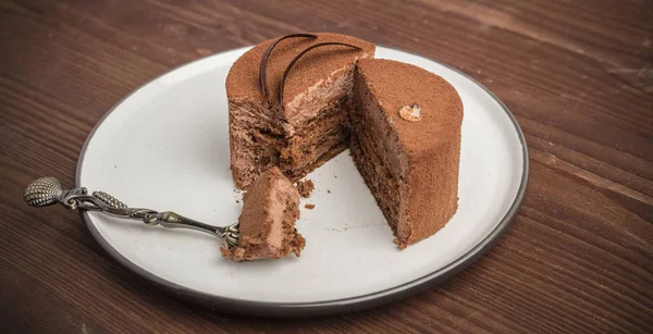 Ahşap bir masa üzerinde bir tabak içinde çikolatalı kek