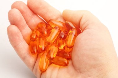 Balık yağı kapsülleri kopya alanı ile beyaz bir arka plan üzerinde bir elinde 