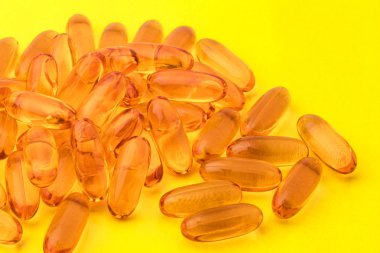 Gelen sarı bir arka plan üzerinde balık yağı Omega 3 kapsülleri. Kopya alanı 
