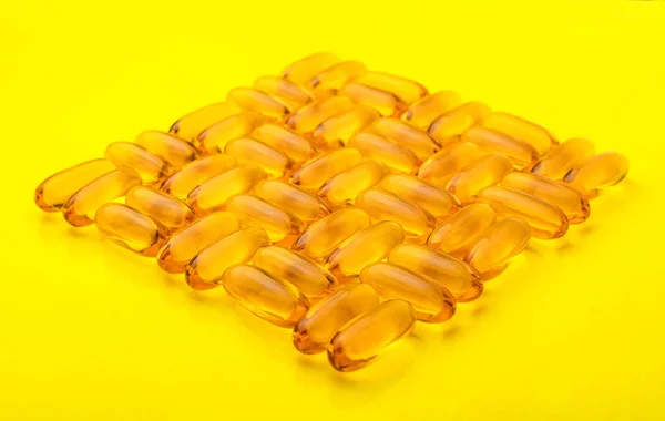 Omega Capsules Fish Oil Yellow Background Texture Pattern Copy Space — Stock Photo, Image