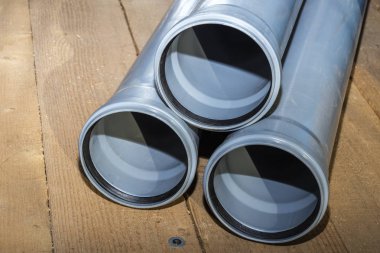 Bir ahşap zemin arka plan gri Pvc kanalizasyon boruları. Kopya alanı