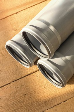 Bir ahşap zemin arka plan gri Pvc kanalizasyon boruları. Kopya alanı