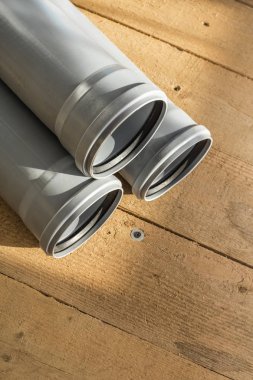Bir ahşap zemin arka plan gri Pvc kanalizasyon boruları. Kopya alanı
