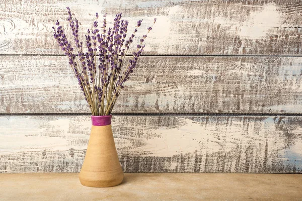 bouquet of lavender in a vase on a wooden background. Dried lavender. Copy space