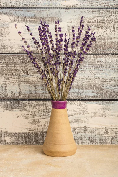 bouquet of lavender in a vase on a wooden background. Dried lavender. Copy space