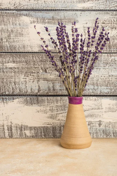 bouquet of lavender in a vase on a wooden background. Dried lavender. Copy space