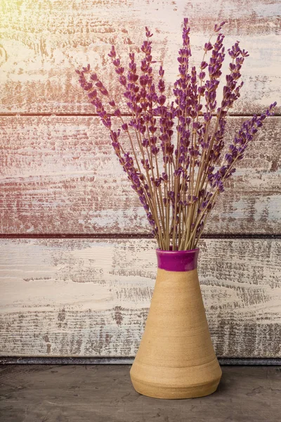 bouquet of lavender in a vase on a wooden background. Dried lavender. Copy space