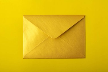 Sarı bir arka plan üzerinde altın zarf. Mock-up