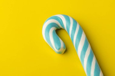 Noel Candy Cane sarı zemin üzerine mavi fiyonklu. Kopya alanı 