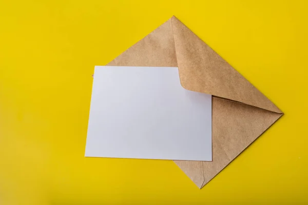 Mock-up letter or postcard with envelope from Kraft on a yellow background