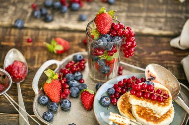 taze berry çilek, yaban mersini ve metal tepsi üzerinde kırmızı kuş üzümü şube ile sufle krep. sağlıklı kahvaltı