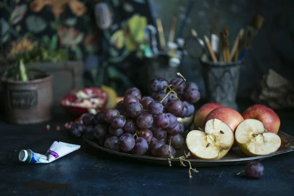 fresh fruit on a tray, grapes and red apples, dark background. Copy space