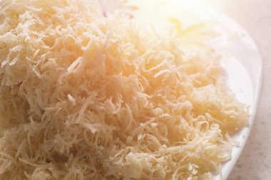 bir tabakta yumuşak peynir rendeleyin. peynir makarna, risotto ve rendelenmiş salatalarda kullanılır