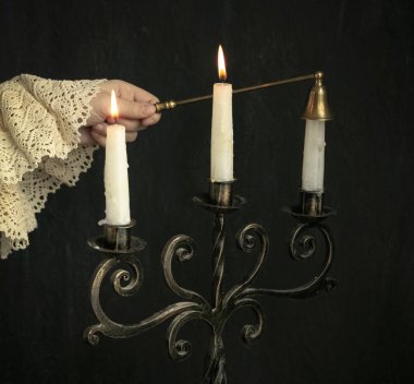 bir çocuğun eli bronz bir kandelabrum mum alev söndürür. Vintage Konsept fotoğraf, ev tatlı ev, dünya bilgisi, eğitim, özgünlük