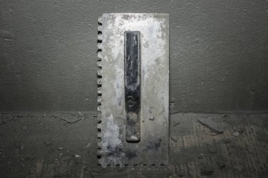 Çimento bir duvarın arka plan üzerine fayans döşeme için eski mala. Onarım için araçlar. Kopyalama alanı