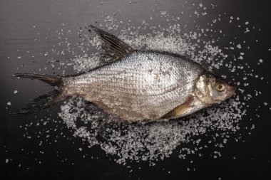 Taze çipura balık kaba deniz tuzu serpilir. Mutfak masası. Üstte görüntüle. Tuzlama balık