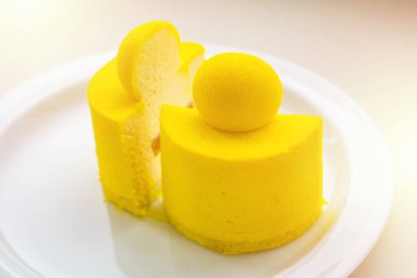 Mango ve tutku meyve ile Krem cheesecake. Bir tabakta bir minicort kesin