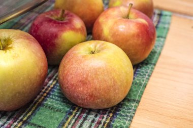 Mutfak masasında kırmızı renkli tatlı elmalar. Yıkanmış sebzeler, sağlığın garantisi. Kopyalama alanı