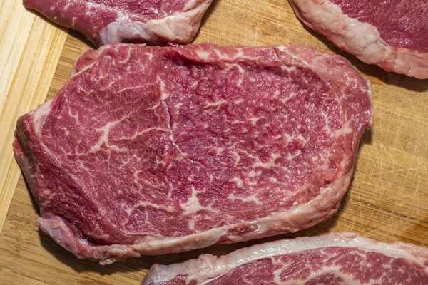 木製の背景に生のステーキ 新鮮な肉 トップビュー — ストック写真