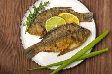 Kızarmış balık limon dilimleri ile limon dilimleri ve taze otlar ile dekore edilmiştir. Hazır yemek yakın. Üstte görüntü