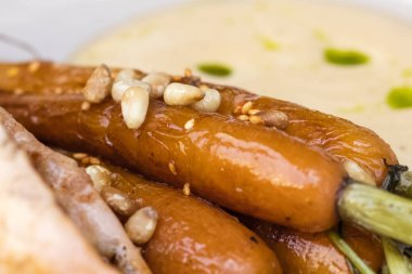 Genç havuç sıcak yağda kızartılmış ve çam fıstığı ile süslenmiş. Yakın çekim