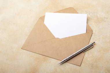 Kraft zarfında açık bir arka plan üzerinde boş kağıt. İmzalarınız için kartpostal temizleyin. Kopyalama alanı