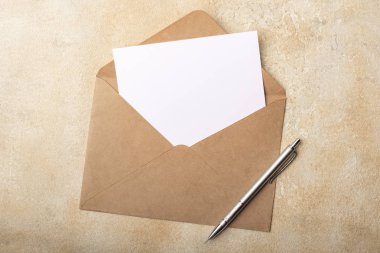 Kraft zarfında açık bir arka plan üzerinde boş kağıt. İmzalarınız için kartpostal temizleyin. Üstte görüntü